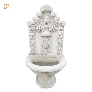 Wall-mounted marble fountain with lion head and floral carvings